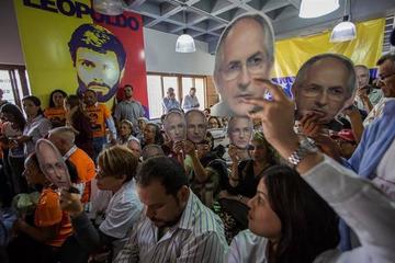 Un grupo de personas con afiches alusivos a Leopoldo López y Antonio Ledezma asiste a una rueda de prensa.