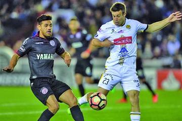 Lautaro Acosta pugna por el balón con Matias Alonso.