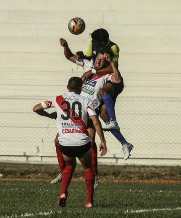 El zaguero de la banda roja Víctor Galaín trata de despejar el balón.