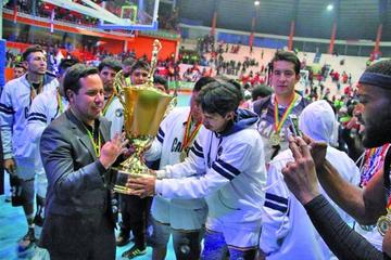 El DT Giovanny Vargas sostiene el trofeo junto a su equipo.