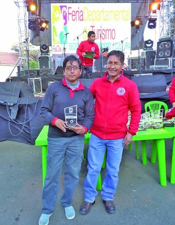 El representante de Tomave recibe la plaqueta del secretario Marco Suyo.