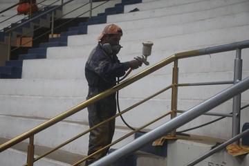 Trabajadores pintan las barandas.
