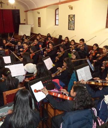 Los músicos de la orquesta de violines.