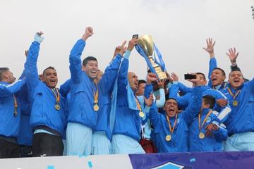 Los campeones levantan en alto el trofeo.