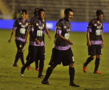 Los jugadores lilas abandonan el campo de juego alicaídos.
