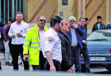 El personal de servicios de emergencia en Irán asiste a los familiares de las víctimas del siniestro.