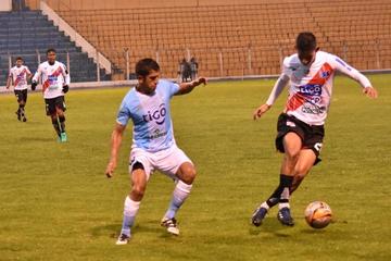 Jorge Flores trata de esquivar la marca  de su adversario.
