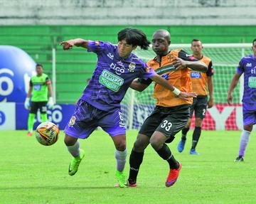 El jugador lila, Eduardo Puña, controla la pelota ante la marca de su rival.