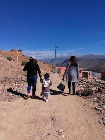 La niña es llevada a su casa de la mano por su madre.