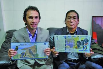 Roberto Rodríguez y Abraham Pérez muestran las imágenes en grande del billete de 10 Bolivianos.