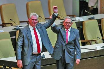 El nuevo mandatario cubano saluda junto al primer secretario del Partido Comunista de Cuba y expresidente Raúl Castro.