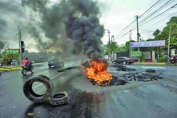 Manifestantes levantan una barricada en protesta contra el alza del combustible.