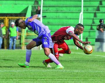 Los futbolistas se disputan el balón.