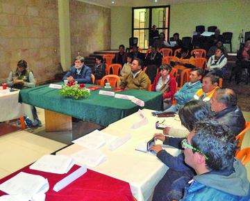 Los participantes escuchan la lectura del acuerdo.