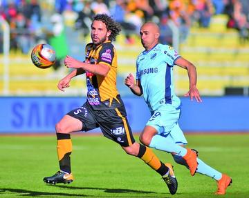 Fernando Marteli cubre el balón ante la arremetida de Marcos Riquelme.
