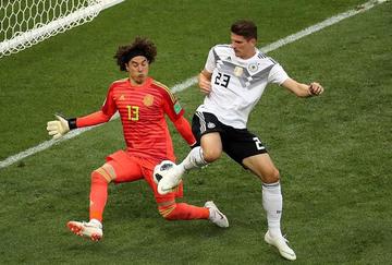 El portero de México, Guillermo Ochoa, ataja el balón a Mario Gomez.