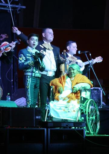 El artista mexicano le canta a una anciana.