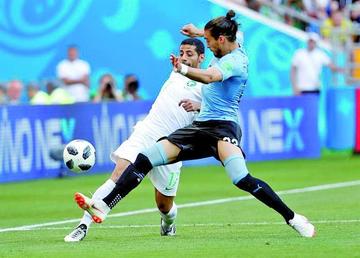 Jassam, de Arabia Saudi, disputa en balón con Cáceres, de Uruguay.