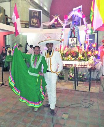 Una pareja de bailarines delante de la imagen del apóstol San Bartolomé.