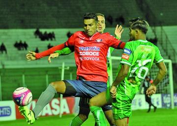 Gilbert Álvarez es cercado por dos jugadores del cuadro local.