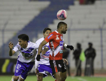 El delantero Harold Reina, de la banda roja, cabecea el balón.