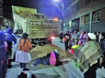 Una mujer se echa para impedir la descarga de material.