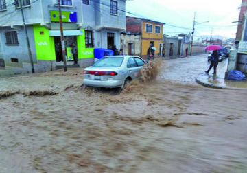 El agua que bajaba por la calle Smith casi cubría los vehículos.