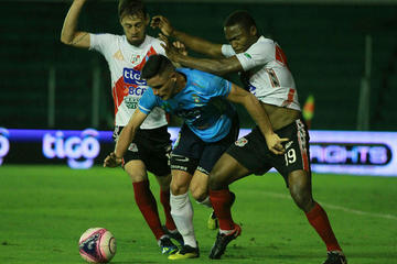 Victor Galaín y Henry Alaca, de Nacional, quitan el balón a su rival.