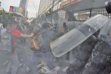 Activistas del 21F lanzaron objetos y agredieron  a los policías que respondieron con el uso de la fuerza y gases