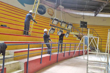 Trabajadores bajan los reflectores antiguos.