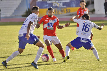 Harold Reina (c) trata de esquivar a sus rivales.