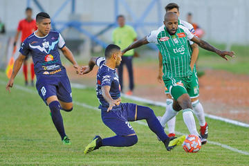 La defensa local trata de frenar a su rival.