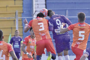 Óscar Velásquez y Juan Vogliotti pugnan el balón en el aire.