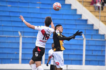 El defensor Víctor Galaín, de la banda roja, cabecea la pelota.