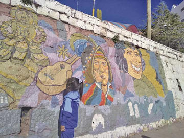 Una niña observa un mural de Potosí cuna del charango. Fue ayer, en el Día del Peatón.