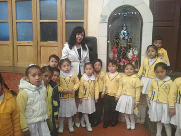 La directora del Kinder Andrea Arias y Cuiza, Delina Reyes, junto a algunos de sus alumnos.