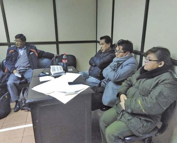 El imputado al lado de una policía y de su abogado en la audiencia cautelar.