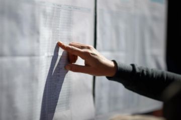 Votante buscando su nombre en las listas.