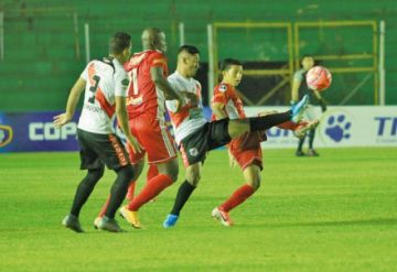 Miguel Quiroga (c) pugna el balón con sus rivales.