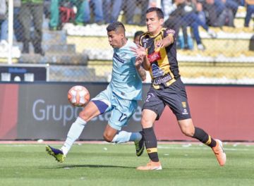 Juan Carlos Arce, de Bolívar, protege el balón de su rival.