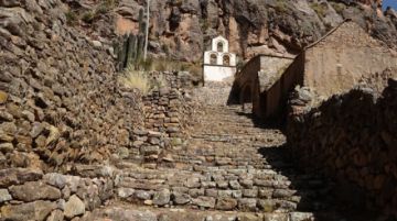 Escalinata de piedra y, arriba, la espadaña del templo.