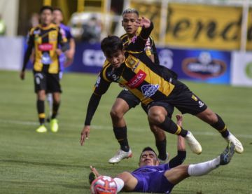 Christian Vargas (piso) trata de detener a su rival.