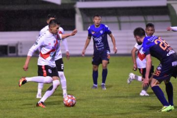 Luis Torrico trata de pasar la marca de sus rivales.