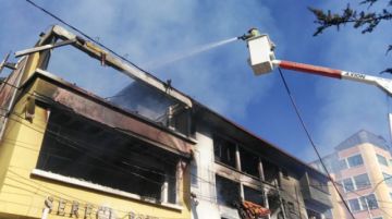 Un bombero usa un carro balde para sofocar el incendio.