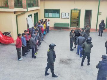 Vista general de los arrestados y policías.