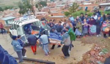 Pobladores introducen el cuerpo del fallecido a una ambulancia.