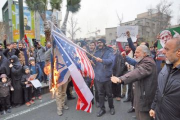 Iraníes queman las banderas de Estados Unidos y de Israel en una protesta en Teherán, la capital.