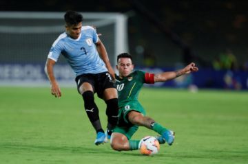 Henry Vaca (d), de Bolivia, disputa un balón con Douglas Arezo, de Uruguay.