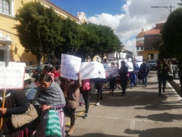 Las mamás y papás portan carteles de protesta pidiendo justicia.