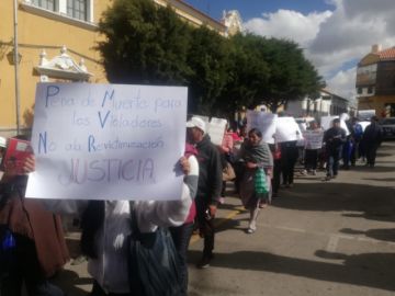 Las mamás y papás portan carteles de protesta pidiendo justicia.